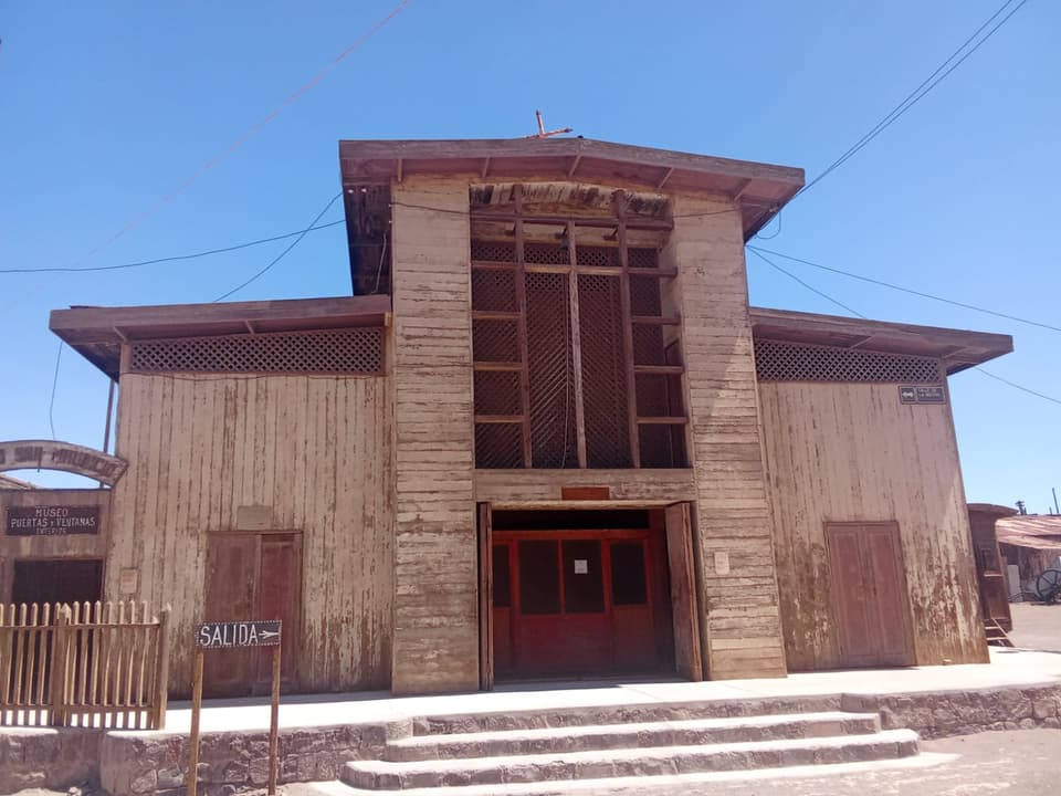 Fachada de la iglesia de madera con celosías y escalinata de piedra